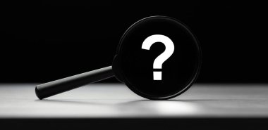 Tahta masanın üzerinde soru işareti olan büyüteç. Arama kavramı