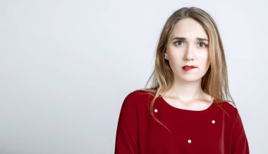 Uzun sarı saçlı dalgın Avrupalı genç kadın kötü düşüncelerden rahatsız oluyor. Beyaz arka planda izole edilmiş. Metnin için boşluk kopyala