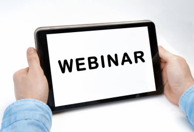 Beyaz arkaplan üzerinde WEBINAR metni olan tableti tutan erkek eller, kavram