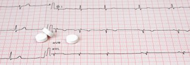 Elektrokardiyografide suni kalp pili kalp pili ve masa üstünde haplar. Seçici odak