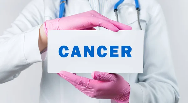 白衣とピンクの滅菌手袋で若い女性医師のクロップビューは テキスト癌とカードを保持します 医学的概念 — ストック写真