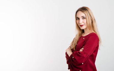 Aşk, şefkat konsepti. Beyaz arka planda, göğsünde çapraz kollar olan, uzun sarı saçlı çekici Avrupalı genç bir kadın. Metnin için boşluk kopyala