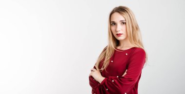 Aşk, şefkat konsepti. Beyaz arka planda, göğsünde çapraz kollar olan, uzun sarı saçlı çekici Avrupalı genç bir kadın. Metnin için boşluk kopyala