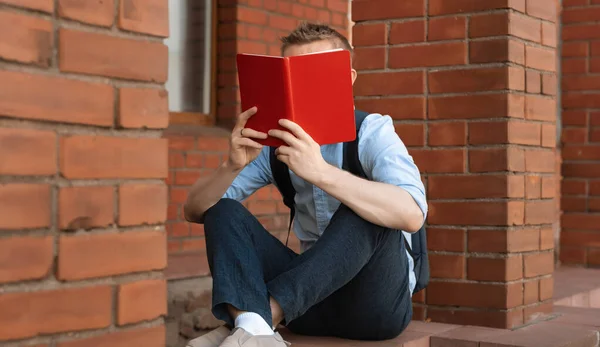 Avrupalı Erkek Öğrenci Kütüphanenin Yanında Oturuyor Bir Kitap Okuyor Kişisel — Stok fotoğraf