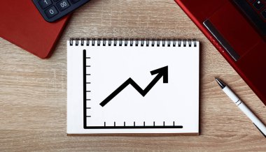 Not defterindeki iş büyüme grafiği. Dizüstü bilgisayarı ve kalemi olan bir not defteri.