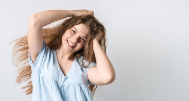 Çekici, kaygısız Avrupalı bir kızın portresi başını öne eğmiş ve kıvırcık saçlarını sallıyor. Doyana kadar yaşamak. Eğlenmek ve eğlenmek. Metnin için boşluk kopyala