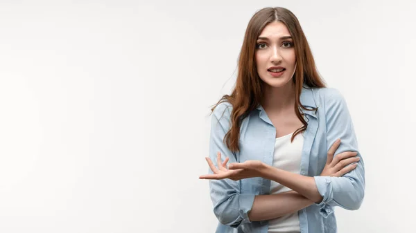 Uzun kestane rengi saçları olan, günlük giysiler giymiş, omuz silkmiş, kafaları karışmış, sorularla karışmış, seçimini yaparken şüpheyi hisseden bir kızın stüdyo fotoğrafı. İnsan duyguları kavramı