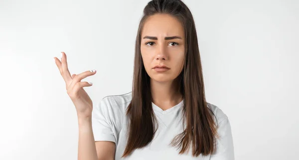 What the hell are you talking about, nonsense. Studio shot of frustrated female with long chestnut hair gesturing with raised palm, frowning, being displeased and confused with dumb question.