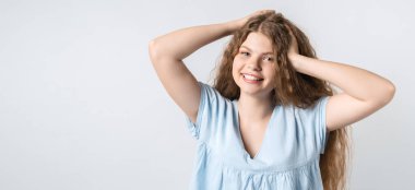 Çekici, kaygısız Avrupalı bir kızın portresi başını öne eğmiş ve kıvırcık saçlarını sallıyor. Doyana kadar yaşamak. Eğlenmek ve eğlenmek. Metnin için boşluk kopyala