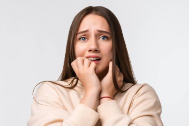 - Korkuyorum. Korku, fobi, panik atak, korku. Uzun kestane rengi saçlı, şık bej kapüşonlu, beyaz arka planda soyutlanmış korkmuş kadının portresi.