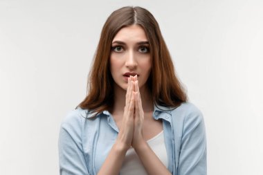 Uzun kestane rengi saçlı genç bir kadın namaste tabelasında el ele tutuşuyor. İçeride meditasyon yapar, huzur ve sevgi için dua eder sakin ve huzurlu bir yüz ifadesi takınır. Rahatlama kavramı