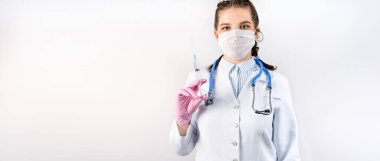 Beyaz önlüklü, tıbbi maskeli ve pembe steril eldivenli genç bir kadın doktor şırınga tutuyor. Aşı konsepti. Metnin için boşluk kopyala