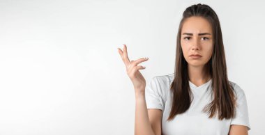 What the hell are you talking about, nonsense. Studio shot of frustrated female with long chestnut hair gesturing with raised palm, frowning, being displeased and confused with dumb question.