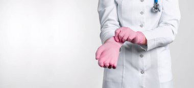 Üniformalı kadın doktorun beyaz arka planda izole edilmiş pembe steril eldivenler giydiği görüntüler. Tıbbi konsept