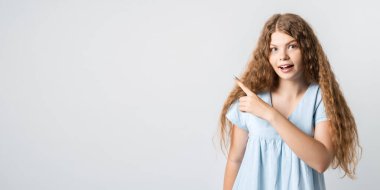 Görsen iyi olur. Kıvırcık saçlı, sıradan giyinmiş, gülümseyen ve işaret parmağıyla işaret eden mutlu sarışın kız imajı reklama yer veriyor. Stüdyo fotoğrafı, beyaz arka plan. İnsanlar, reklam kavramı