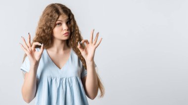 Kıvırcık, uzun saçlı çekici sakin bir kadın iki eliyle işaret ediyor, onaylıyor, beyaz arka planda izole edilmiş. Metnin için boşluk kopyala