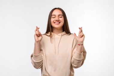 Uzun düz saçlı neşeli, genç esmer kadın parmaklarını çapraz yapar, arzulanan dilekler diler, gündelik kıyafetler giyer, iyi haberleri bekler. İnsani duygular, yüz ifadesi kavramı.