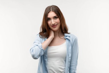 Kafası karışmış, uzun düz saçlı, genç, esmer bir kadın. Şefkatli bir gülümsemesi var. Elini boynuna koyuyor. Pozitif duygu kavramı