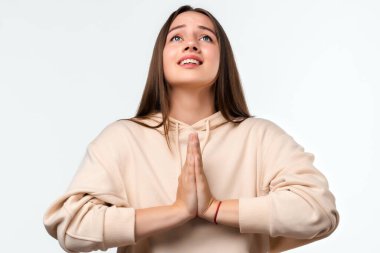 Uzun saçlı, mutlu esmer bir kadının resmi. Gülümseyen ve avuçlarını bir arada tutan sıradan kıyafetler giymiş bir kadın. Meditasyon yapıyor, barış ve sevgi için dua ediyor, sakin ve huzurlu bir yüz ifadesi var.