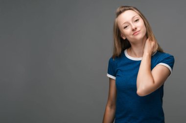 Kızıl saçlı, çilli derili, çizgili, bol tişörtlü, elleri çapraz, kendine güvenen çekici bir kadının stüdyo fotoğrafı. Güzel genç bayan evde yalnız başına dinleniyor.