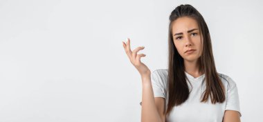 What the hell are you talking about, nonsense. Studio shot of frustrated female with long chestnut hair gesturing with raised palm, frowning, being displeased and confused with dumb question.