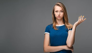 What the hell are you talking about, nonsense. Studio shot of frustrated female with blonde straight hair gesturing with raised palm, frowning, being displeased and confused with dumb question