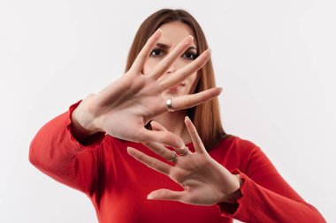 Olmaz, kes şunu. Tatmin olmamış, uzun kestane rengi saçları olan kırmızı kazak giyen ve elleri havada tiksinti reaksiyonu gösteren bir kız resmi. Stüdyo çekimi, beyaz arkaplan