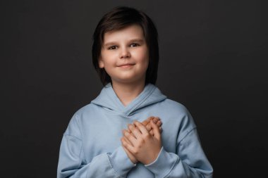 Teşekkür ederim. 10-12 yaşlarında neşeli bir çocuk, günlük kıyafetler giymiş, nazikçe gülümseyen ve avuçlarını kalbime bastıran, hediyeye minnettar olan, her zaman kalbimde olduğunu söyleyen. Pozitif duygular