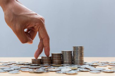 Fingers walking up on coins stack or money stack and row of coin on wooden table. Financial, Business growth concept. Investment and saving concept