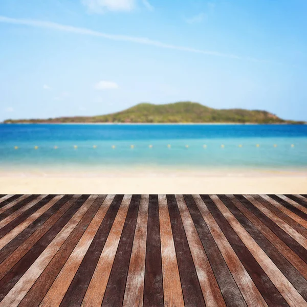 Wooden floor on beach with mountain and cloudy background. For your product placement or montage with focus to the table top in the foreground. Empty wooden brown shelf. shelves