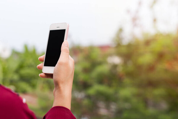 Close up of young woman using mobile phone while standing outdoors