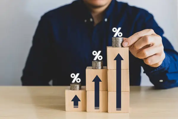 Bozuk paraları farklı yüksekliklerde, yüzdelerle ve ok simgeleriyle üst üste istifleyerek el ele tutuş. Finansal getiriler, faiz oranı ve kar payı kavramı. uzun vadeli yatırım