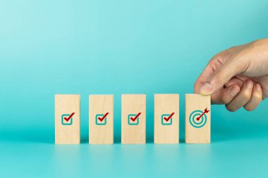 Başarılı bir hedef için ikon hedefli ahşap küpü elle tutun. İş başarısı artışı kavramı