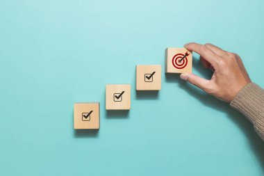 Başarılı bir hedef için hedef simgesi olan ahşap küpü elle tutun. İş başarısı artışı kavramı