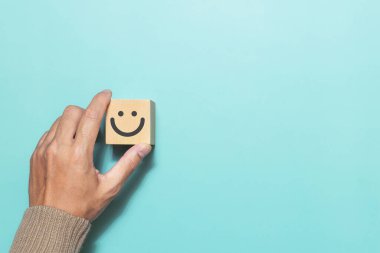 Müşteri derecelendirme için gülen surat ifadesi koyuyor. Hizmet derecesi, geri bildirim, tatmin kavramı