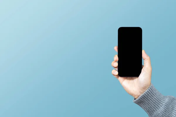 Mavi arka planda boş ekranlı akıllı telefon ya da cep telefonu tutan bir adam. Hizmet derecesi, memnuniyet, müşteri deneyimi konsepti