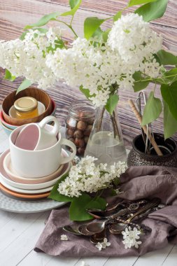 Birçok farklı sofra boş. Beyaz Leylak buket. Ahşap arka plan koyu peçete.