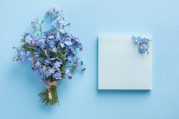 Forget me not flowers bouquet on blue pastel background.