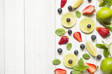 Narenciye kireç taze çilek, yaban mersini hafif bir arka plan üzerinde çilek nane. Metin için yer kopyalayın.