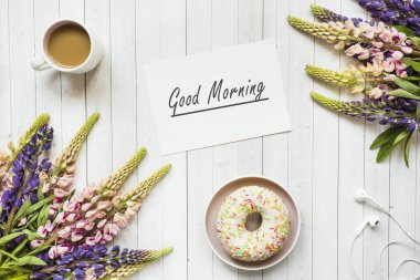 Bir fincan kahve ve acı bakla ile natürmort çörek ahşap masa lambası kopya alanı üzerinde çiçekler