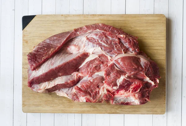 Ahşap Doğrama Kurulu ışık arka plan üzerinde kırmızı çiğ et parçası.