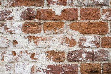 Dökülen alçı ve desenli eski, eski, kirli tuğla duvarın arka planı.