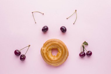 Kek kiraz üzerinde pembe bir arka plan ile muhallebi ile domuz yüzleri. Seçici odak