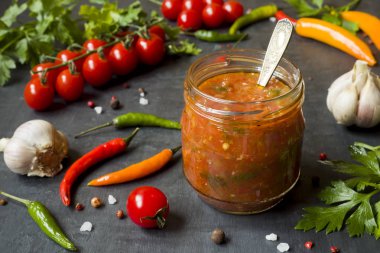 Sosu ketçap, Lecho cam. Biber kiraz domates sarımsak ve diğer baharatlar siyah arka plan üzerine.