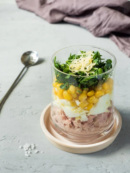 Yumurta Mısır yeşillikleri beton bir tabloda bir cam bardak ile taze ton balığı salatası. kopya alanı.