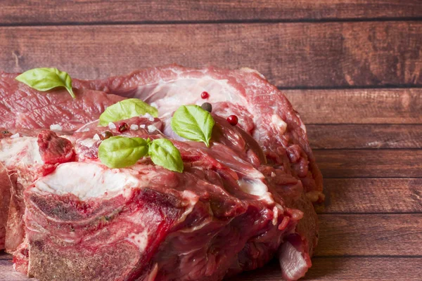 Ahşap kesme tahtası koyu arka plan üzerinde kırmızı ham sığır et parçası.