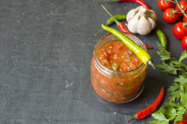 Sosu ketçap, Lecho cam. Biber kiraz domates sarımsak ve diğer baharatlar siyah arka plan üzerine.
