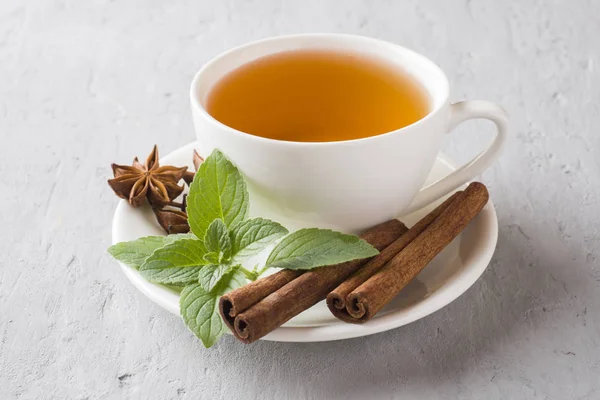 Çay taze nane yaprakları ve gri beton zemin üzerine tarçın Yıldız anason ile.