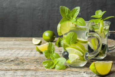 Serinletici içecekler limonata yaz ya da kireç taze nane yaban mersini buzla kokteyl Mojito. Ahşap arka plan.