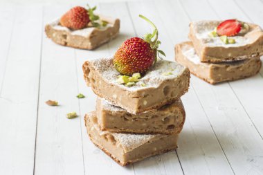 Çilek ile süzme peynir güveç kısmında ve nane, Antep fıstığı hafif bir arka plan üzerinde. Kahvaltı kavramı.